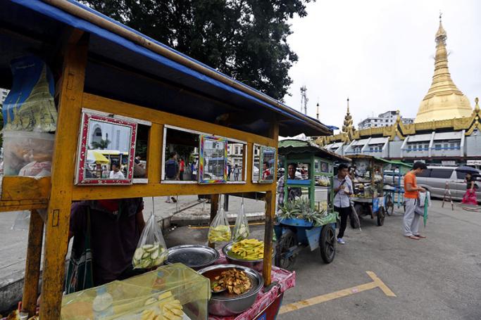 Street vendors sell snacks near the Sule pagoda in downtown Yangon, Myanmar. Photo: Nyein Chan Naing/EPA
