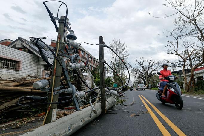 A Taiwanese drives past broken electric post caused by super typhoon Nepartak in Taitung County, southeastern Taiwan, 09 July 2016. Photo: Ritchie B. Tongo/EPA

