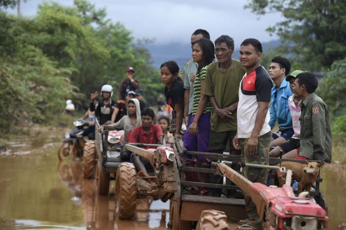 (FILES) In this file photo taken on July 27, 2018 flood victims wait for food aid in Sanamxai, Attapeu province. Thousands are languishing in displacement camps a year after a dam broke unleashing floodwaters and killing dozens of people in the impoverished state, a new report on the anniversary of the disaster said July 23, 2019. Photo: Nhac Nguyen/AFP