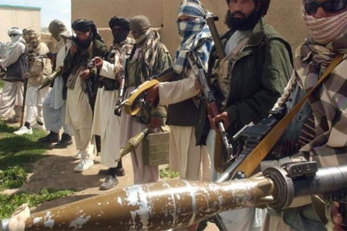 Taliban militants in a line holding guns and explosives. Photo: AFP