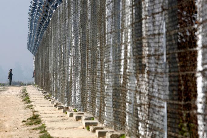 An armed policeman stands guard beside the fence near the Taungpyo Bangladesh-Myanmar border gate where the repatriation process planned to take place in Maungdaw district, Rakhine State of western Myanmar, 24 January 2018. Photo: Lynn Bo Bo/EPA
