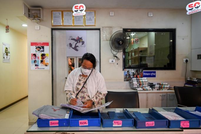 In this picture taken on March 22, 2022, a doctor goes through medical files at the Médecins Sans Frontières (MSF) clinic, which treats people with drug-resistant tuberculosis, in Mumbai. Photo: AFP