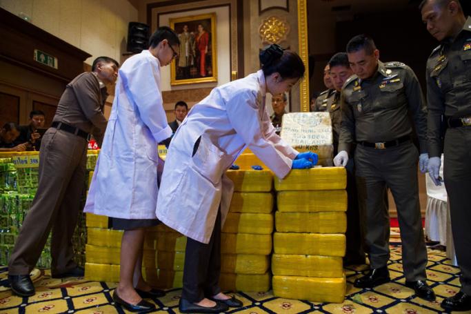 Thai national police chief general Chaktip Chaijinda (2nd-R) watches police department chemists inspect seized drugs during a press conference in Bangkok on May 11, 2018. Ten million made-in-Myanmar 'yaba' pills and nearly half a tonne of crystal meth hidden in tea packages has been seized from a convoy cars in downtown Bangkok, Thai police said. Photo: Romeo Gacad/AFPA