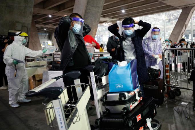 Chinese tourists put on raincoats and face shields as part of the COVID-19 coronavirus pandemic restrictions upon their arrival at Suvarnabhumi Airport in Samut Prakan province, Thailand, 20 October 2020. Photo: Rungroj Yongrit/EPA