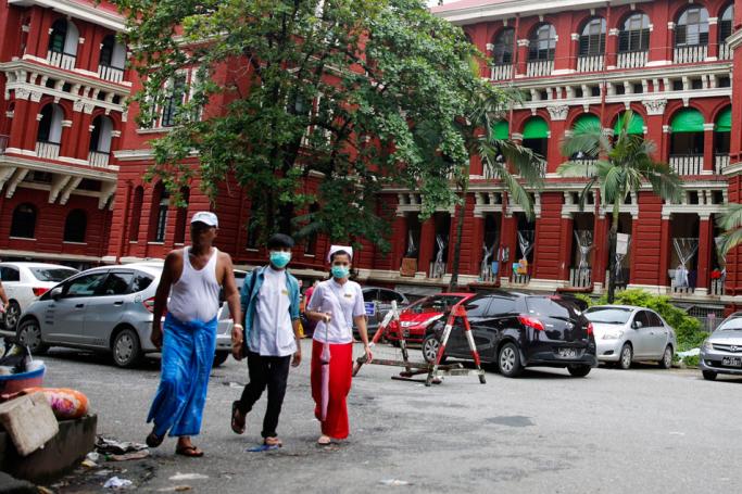 People wear masks as they walk in front of Yangon General Hospital in Yangon. Photo: Lynn Bo Bo/EPA