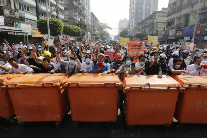(FILE) - Demonstrators stand behind a barrier of waste containers as they face riot police during an anti-military protest in Yangon, Myanmar, 28 February 2021. Photo: EPA