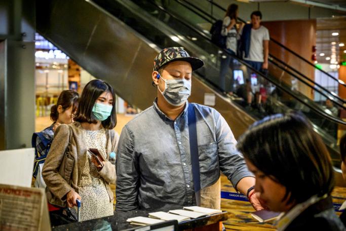 Passengers wearing face masks board their flight at Yangon International Airport on January 21, 2020. Photo: Mladen Antonov/AFP