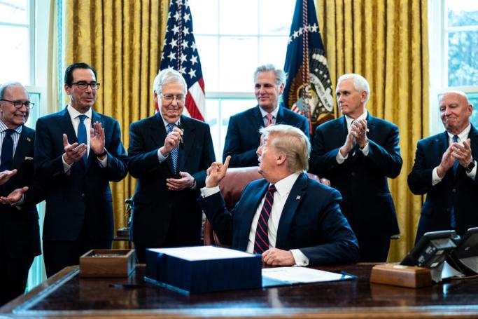 US President Donald J. Trump (C) hands a pen to Republican Senate Majority Leader Mitch McConnell (3-L) during a signing ceremony for the The CARES Act in the Oval Office at the White House in Washington, DC, USA on 27 March 2020. Photo: EPA