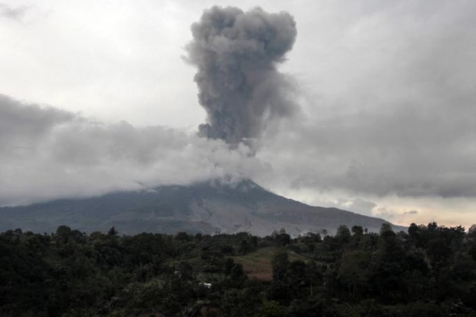 This picture taken at the Tiga Pancur village in Karo, North Sumatra on August 17, 2020, shows Mount Sinabung spewing thick smoke. Photo: Ivan Damanik/AFP