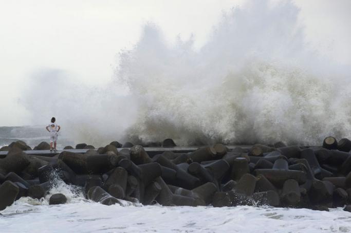 A Japanese surfer watches high waves from Typhoon Etau hit a breakwater in Isumi city, Chiba prefecture, Japan, 09 September 2015. Photo: Everett Kennedy Brown/EPA
