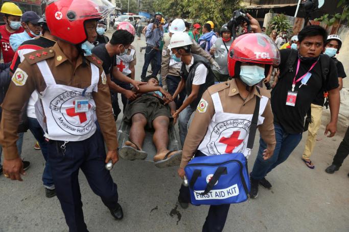 An injured man is carried on a stretcher by medical staff after police fired at demonstrators during a protest against the military coup in Mandalay, Myanmar, 20 February 2021. Photo: Kaung Zaw Hein/EPA