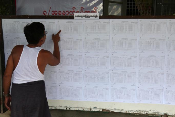 A resident checks voting lists at an administrative office in Yangon on July 25, 2020, ahead of the upcoming general election set for later in the year. Photo: Sai Aung Main/AFP