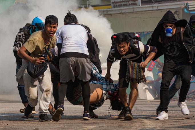 Protesters carry a wounded man shot with live rounds by security forces during a crackdown on demonstrations against the military coup in Yangon on March 17, 2021. Photo: AFP
