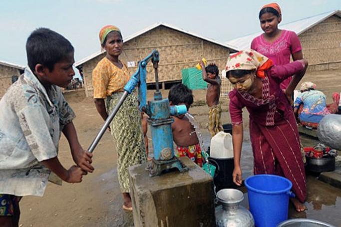 (File) Rohingya Muslims collect water from a well near their barracks at the Bawdupah IDP camp on the outskirts of Sittwe in Myanmar's Rakhine state. Photo: AFP
