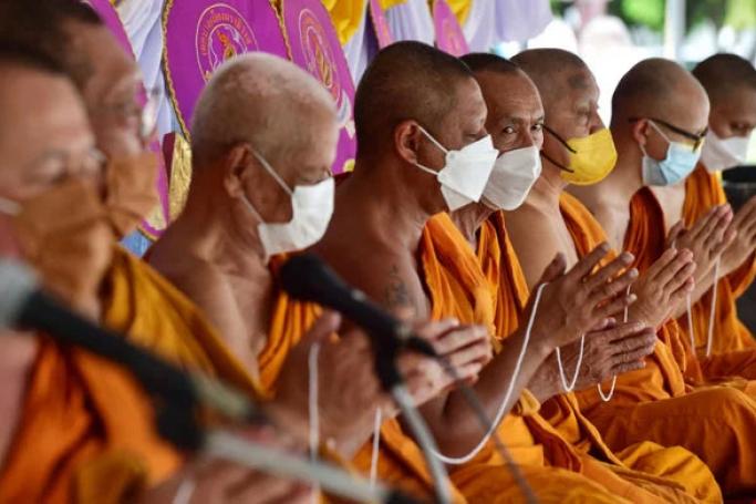Monks gesture during an event ahead of the Buddhist festival Asanha Bucha at Bang Nara temple in the southern Thai province of Narathiwat on July 8, 2022. Photo: AFP