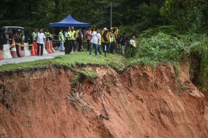 People inspect the damage after a landslide in Batang Kali, Selangor on December 16, 2022. Photo: AFP