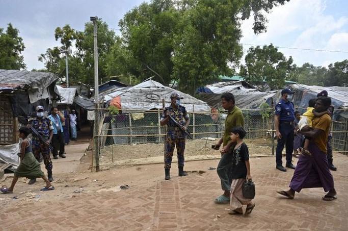 Law enforcement officials stand guard near the office of slain community Rohingya leader Mohib Ullah, who was shot dead by gunmen at Kutupalong refugee camp in Ukhia on Oct. 6, 2021. (AFP)