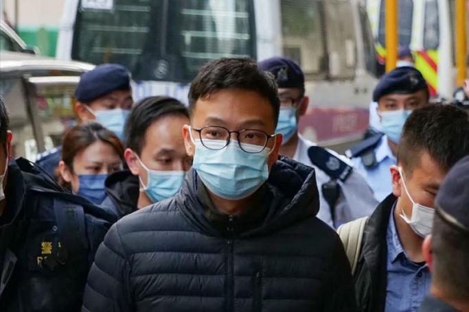 Stand News chief editor Patrick Lam is brought to the news outlet's office building in handcuffs after police were deployed to search the premises in Hong Kong's Kwun Tong district on December 29, 2021. -AFP PIC