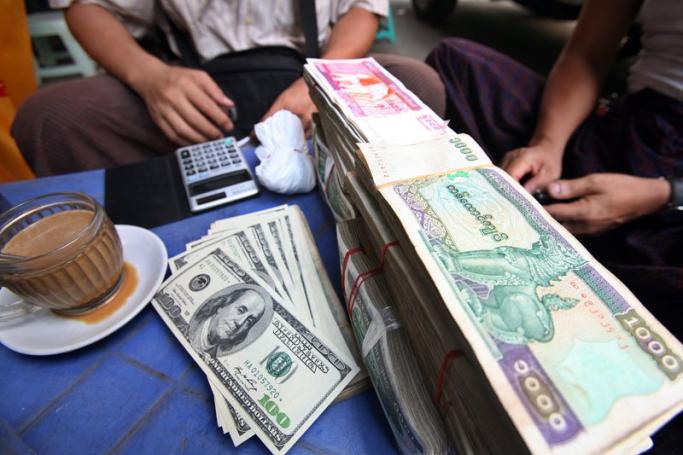 People exchange US dollar and Myanmar currency at a black market in Yangon, Myanmar. Photo: EPA
