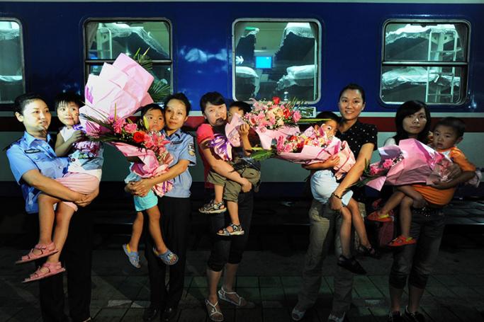 (Files) Chinese police and parents show off the five children rescued from human traffickers, after they arrived back in Guiyang, southwest China's Guizhou province on July 24, 2009. Photo: AFP
