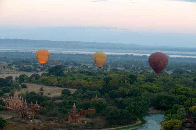 Balloons carrying visitors sit in the sky during sunrise in Bagan, Myanmar. Photo: Nyein Chan Naing/EPA