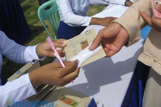 A voter shows an official their identification paper prior to voting in 2010. Photo: Mizzima
