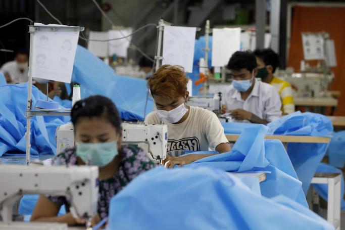  Workers make disposable surgical gown at a garment factory in Yangon, Myanmar. Photo: EPA