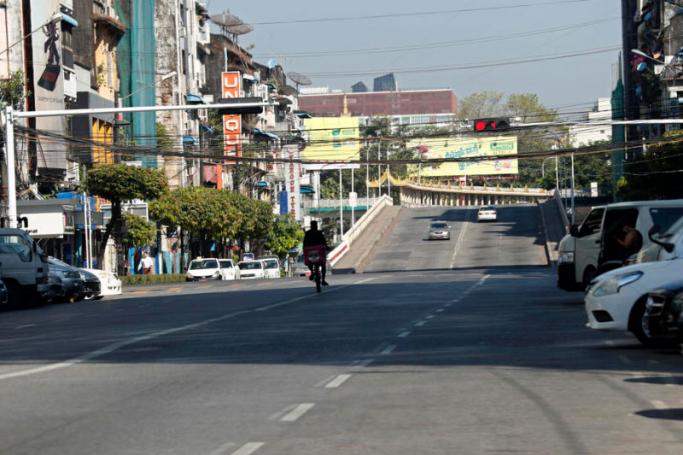 A delivery man from Food Panda rides his bicycle in an empty street in downtown Yangon, Myanmar. Photo: EPA