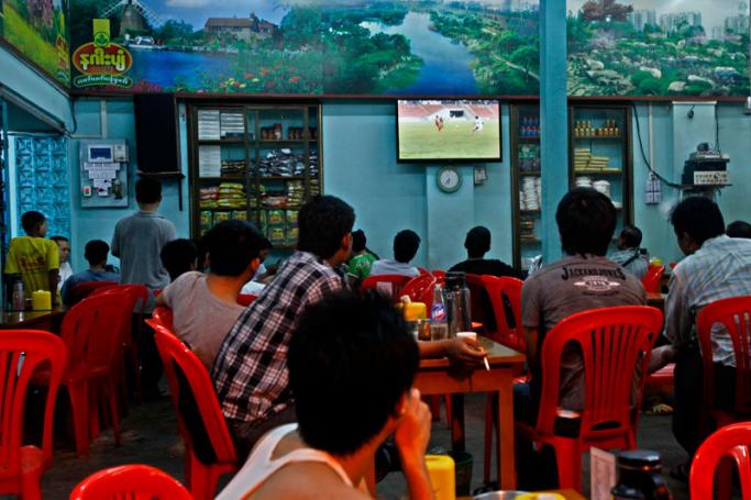 Watching a football match in a tea shop in Yangon. Photo: Lynn Bo Bo/EPA
