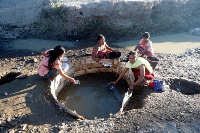 Rakhine ethnic women, who fled from conflict areas, collect water from a well at War Myat Hall village's temporary camp in Ponnagyun Township, northern Rakhine State, western Myanmar. Photo: EPA