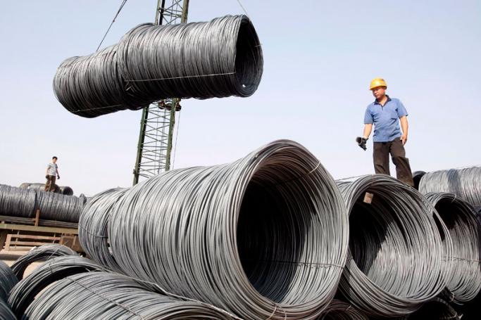A file photo dated 04 June 2007 showing workers transporting steel cables at a steel yard in Beijing, China. Photo: Michael Reynolds/EPA
