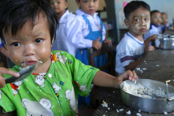 Young children eat food in a child care center in Nay Pyi Taw. Photo: EPA