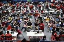 Teenagers accompanied by parents wait for their turn to receive the BioNtech-Pfizer Covid-19 coronavirus vaccine during the innoculation of the population aged 12-17 at a stadium in San Juan City, suburban Manila on November 3, 2021. Ted ALJIBE / AFP