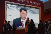 Visitors walk in front of a screen showing China's President Xi Jinping at the Museum of the Communist Party of China in Beijing on November 11, 2021. Noel Celis / AFP