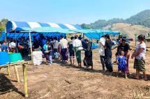 People fleeing due to fighting between the military and the Karen National Union (KNU) line up to receive food at a temporary lodging for internally displaced people (IDPs) in Karen state. Photo: AFP
