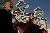 People walk past the logos of the Beijing 2022 Winter Olympics and Paralympic Winter Games in Beijing on January 18, 2022. Noel Celis / AFP