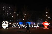 A woman walks past installations of Bing Dwen Dwen (L) and Shuey Rhon Rhon (R), mascots of the Beijing 2022 Winter Olympics Games, along a street in Beijing on January 28, 2022. Jade Gao / AFP