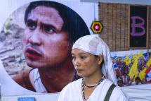 Pinnapha Phrueksapan, widow of ethnic Karen leader Por Cha Lee Rakcharoen -- known as Billy, stands beside the portrait of her late husband following a ceremony in Bangkok on September 16, 2019. The wife of a murdered activist whose charred remains were found dumped in a Thai reservoir led an emotional memorial on September 16, saying their five young children had been left bereft by his death. Photo: AFP