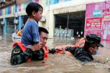 Rescuers evacuating a child from a flooded area following heavy rains in Suizhou, in China's central Hubei province, on August 12, 2021. Photo: AFP