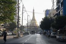 People walk next to Shwedagon Pagoda on an empty road in Yangon on February 1, 2021. Photo: AFP