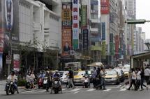 Taiwanese people walk in a street next to different shopping stores in Taipei, Taiwan. Photo: EPA