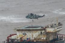 This handout photograph taken on May 18, 2021 and released by the Indian Navy shows stranded workers from a barge, which had gone adrift amidst heavy rain and strong winds due to Cyclone Tauktae, being airlifted by naval personnel on an Indian Navy Seaking helicopter during an evacuation operation, in the Arabian sea. Photo: Indian Navy/AFP