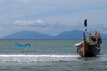 A fishermen boat (L) sails next a boat used by Rohingya refugees to arrive in Lamnga beach, Aceh province on January 8, 2023. Photo: AFP