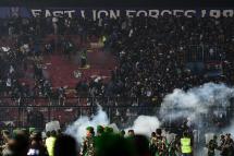 This picture taken on October 1, 2022 shows security personnel (lower) on the pitch after a football match between Arema FC and Persebaya Surabaya at Kanjuruhan stadium in Malang, East Java. Photo: AFP
