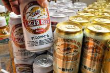 A customer picking up a can of Kirin beer at a liquor shop in Tokyo, Japan. Photo: EPA
