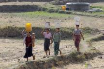 Myanmar women carrying buckets on their heads collect drinking water from the outskirts of Naypyitaw, Myanmar. Photo: EPA
