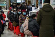 People wearing facemasks queued up to be tested at a hospital in Wuhan. Photo: Hector Retamal/AFP