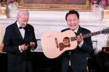 South Korean President Yoon Suk-yeol (R) of the Republic of Korea holds up an acoustic guitar signed by Don McClean as US President Joe Biden looks on during the State Dinner held in the East Room of The White House in Washington, DC, USA, 26 April 2023. EPA-EFE/Oliver Contreras 