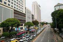 Vehicles travel along Sule Square, office and hotel area of Sule Road in central Yangon. Photo: AFP