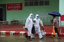 Medical workers wearing personnel wearing PPE (Personal protective equipment) walk past the Fever Corner of a hospital in Sittwe, Rakhine State, western Myanmar, 24 August 2020. Photo: Nyunt Win/EPA